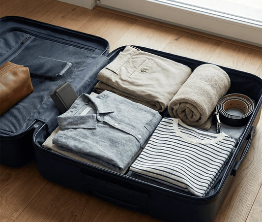 Traceur GPS compact posé dans une valise ouverte avec vêtements et accessoires - protection antivol bagages en voyage